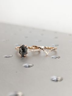 a black diamond ring sitting on top of a metal surface with drops of water around it