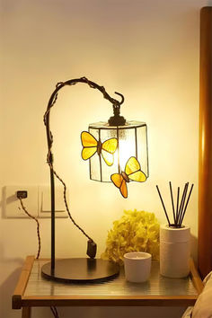 a lamp that is sitting on top of a table next to a vase with flowers