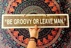 a person holding up a wooden sign that says be grooy or leave man