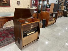 an old fashioned radio sitting on top of a wooden table in a room filled with furniture