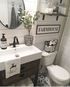 a white toilet sitting next to a sink in a bathroom under a mirror and a wooden cabinet