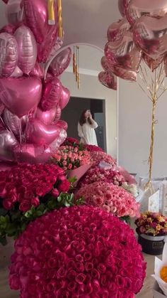 pink flowers and balloons on display in a room