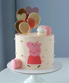 a peppa pig cake with heart shaped balloons on top