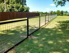 a black fence is in the middle of a grassy field