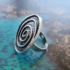 Add a twist to your style with our Silver Swirl Ring, a unique piece that reflects the beauty of boho fashion. Handcrafted in Istanbul, this ring features a mesmerizing spiral design in silver which adds a touch of whimsy - Perfect for those who love to express their individuality. Our Silver Swirl Ring is a large silver ring from our beautiful Anatolian collection, handcrafted in Istanbul by local artisans. Measurements: Length 3.5cm, width 2.5cm (ring size adjustable) Materials: Silver plated Swirl Ring, Authentic Jewelry, Spiral Design, Local Artisans, Zinc Alloy, The Beauty, Unique Pieces, Istanbul, Silver Ring