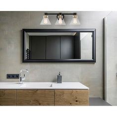 a bathroom vanity with two lights and a mirror