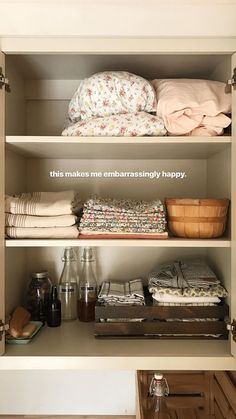 an open closet with linens and other items on the shelves, including blankets and pillows