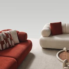 two red and white couches sitting next to each other on top of a rug