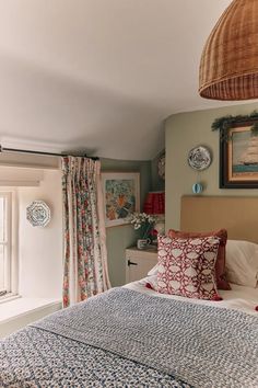 a bedroom with a bed, window and pictures on the wall above it's headboard