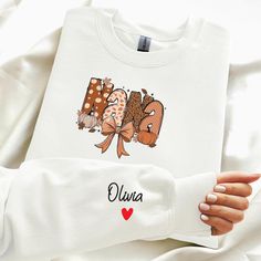 Celebrate the fall season with a touch of personalized warmth and style with our "Nana Fall Sweatshirt"! This cozy and charming sweatshirt is designed to bring a smile to Nana's face, making it a perfect gift for any grandmother and mother who loves to embrace autumn's cozy vibes. HOW TO ORDER 1.Review the size chart and product photos. 2.Select your size and color from the dropdown menus. 3.Click 'ADD TO CART' and adjust quantity if needed. PRODUCT DETAILS *Comfort Colors 100%  ringspun cotton White Long Sleeve Sweater With Name Print, White Sweater With Name Print For Fall, White Fall Sweater With Name Print, Personalized Tops As Fall Gifts, Cute Customizable White Sweatshirt, Cute White Customizable Sweatshirt, Personalized White Tops For Winter, Personalized Cotton Sweatshirt For Fall, Personalized Crew Neck Sweatshirt For Fall