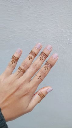 a woman's hand with hennap tattoos on her fingers and fingernails