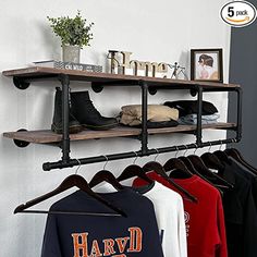 a rack with clothes hanging on it next to a wall