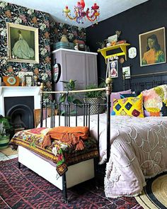 a bed room with a neatly made bed next to a fire place and a painting on the wall