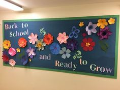 the back to school sign is decorated with paper flowers