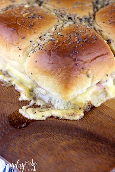 a close up of a sandwich on a wooden table with cheese and black pepper sprinkled on it