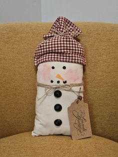 a snowman pillow sitting on top of a couch