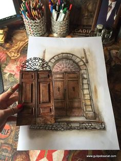 a drawing of an old wooden door in front of a desk with pens and pencils