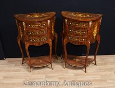 two small wooden tables with drawers on each side and gold decorations on the top, sitting next to each other