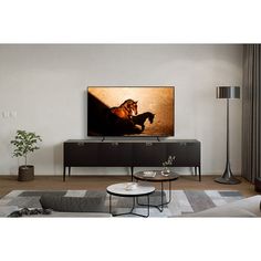 a flat screen tv sitting on top of a wooden entertainment center in a living room