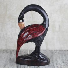 a black and red bird statue sitting on top of a wooden table