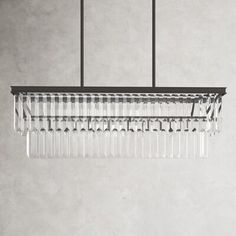 a chandelier hanging from a ceiling in a room with concrete walls and flooring