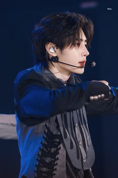 a man with black hair and piercings on his ears