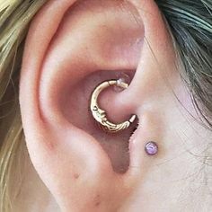 a close up of a person's ear with a gold ring