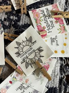 several different types of clothes pins with flowers and sayings on them, all pinned together