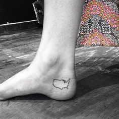 a person with a small tattoo on their foot that is shaped like the state of wisconsin