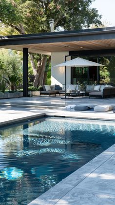 the pool is surrounded by lounge chairs and umbrellas