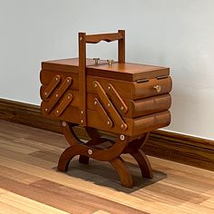 a wooden table with a suitcase on it's legs sitting in front of a wall