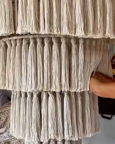 a man is working on some kind of wall hanging project with yarn and wood planks