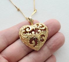 "Vintage ornate cutout filigree goldtone doned metal heart on long vintage goldtone bar chain. the herat pendant is approximately 1-1/2\" tall including the bail. the chain is 30\". it is in good condition consistent with age and use." Valentine's Day Gold Necklace With Intricate Design, Gold Filigree Heart Necklace, Gold Heart Filigree Necklace, Gold Heart Pendant With Intricate Design, Gold Intricate Design Heart Pendant Jewelry, Vintage Filigree Necklace For Valentine's Day, Gold Etched Heart Necklace, Ornate Gold Necklaces For Valentine's Day, Ornate Gold Heart Pendant Jewelry