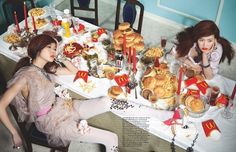 two women sitting at a table with food