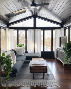 a living room filled with furniture and lots of windows