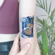 a woman with a guitar tattoo on her arm