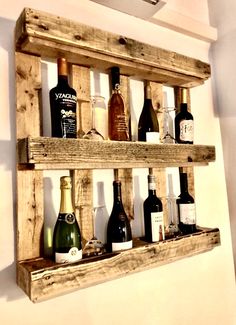 several bottles of wine are arranged in a wooden shelf on the side of a wall