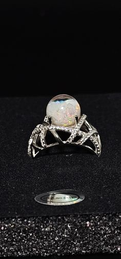 Beautiful 10mm Floating opal ring. The ring is made with only Pure Sterling Silver with beautiful patterns and a mixture of Polished Australian Opals and Kyocera opals.  The ring setting is cast in sterling silver then electroplated with rhodium to provide corrosion protection and enhance the appearance and durability of sterling silver. Gift Ready Box Included Any questions or concerns please contact us. Silver Opal Crystal Ring For Promise, Silver Opal Crystal Ring Fine Jewelry, Iridescent Opal Ring With Unique Style, Unique Iridescent Round Opal Ring, Silver Opal Ring With Accent Stones, Silver Opal Rings With Accent Stones, Unique Silver Opal Ring With Accent Stones, Silver Opal Ring With Round Stone, Silver Opal Ring With Stone Setting