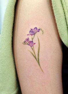 a woman's arm with purple flowers on it