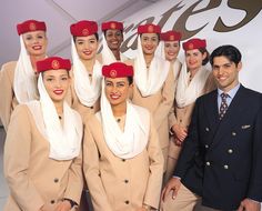 an air hostess poses for a photo with her attendants in their uniforms and headscarves