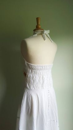 Embroidered sunflowers pop on this gorgeous white cotton-gauze dress. The lacy bodice flares into an ultra-full, handkerchief-hem skirt, with white satin ribbon accents. Easy fit, with a ruched, elasticized back and halter tie at neck. Best fits medium/large sizes. Era: 1970s Label: none ➸ visit on instagram | provenance_vintage Cotton Ruffle Halter Neck Dress, Cotton Halter Neck Dress With Ruffles, White Bohemian Fitted Sundress, White Backless Halter Sundress, White Ruffled Halter Neck Sundress, White Halter Neck Sundress With Ruffles, Bohemian Halter Dress With Smocked Back, White Cotton Sundress With Lace Trim, Vintage White Fitted Sundress