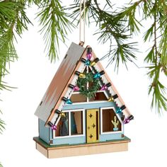 a house ornament hanging from a christmas tree