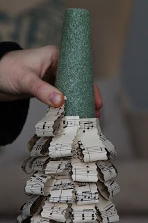 a person holding a piece of paper with music notes on it and a green cone