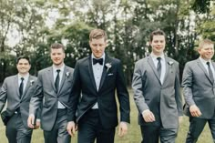 Groom wearing a black tux surrounded by groomsmen wearing grey suits on wedding day Grey Tux Wedding, Charcoal Suit Wedding, Groomsmen Attire Grey, Charcoal Suits, Gray Wedding Party, Slate Blue Bridesmaid Dresses, Black Tux Wedding, Classic Black Suit, Groom Suit Black