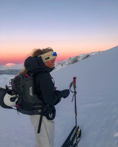 a woman standing on top of a snow covered slope