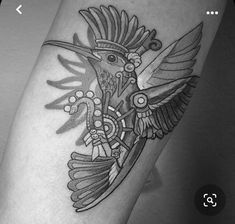 a black and white photo of a bird on someones leg with an intricate design