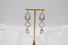 Discover the perfect balance of elegance and whimsy with our Filigree Dangling Peach Stone Earrings. Crafted with expertly faceted fancy cut cubics, these earrings add a touch of sparkle to any outfit. The intricate filigree design showcases the delicate peach stone, creating a timeless and sophisticated look. Length: 2.30” Width: 0.78” Closure: Fish Hook Material: Brass with 18K Gold Plating with Rhodium Coating Lead Free and Hypoallergenic Elegant Faceted Dangle Teardrop Earrings, Elegant Faceted Teardrop Dangle Earrings, Elegant Gold Faceted Crystal Earrings, Elegant Faceted Earrings For Party, Elegant Faceted Chandelier Earrings, Elegant Faceted Party Earrings, Faceted Drop Earrings For Wedding, Elegant Rose Gold Chandelier Earrings, Elegant Rose Gold Crystal Earrings