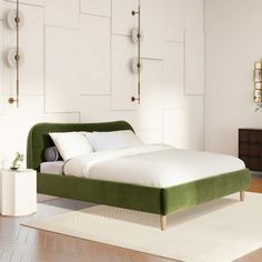 a green bed sitting on top of a wooden floor next to a white rug in a bedroom