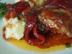 a plate with meat, mashed potatoes and gravy covered in ketchup