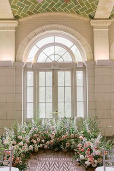 an indoor ceremony setup with flowers and greenery